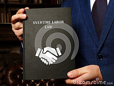 Jurist holds OVERTIME LABOR LAW book. FederalÂ overtime lawsÂ are set forth in the FairÂ LaborÂ StandardsÂ ActÂ FLSA Stock Photo